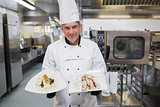 Smiling cook holding two plates