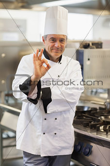 Chef giving ok symbol by the stove