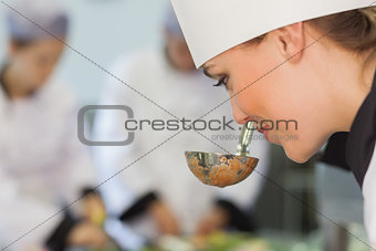 Smiling chef smelling the soup