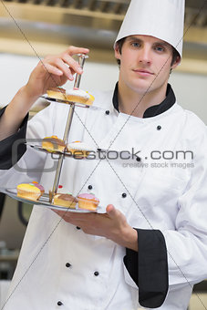 Baker presenting tiered cake tray
