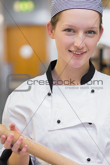 Woman holding rolling pin while smiling