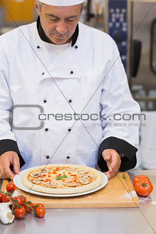 Chef preparing a mushroom pizza