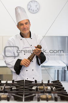 Smiling chef holding a pepper mill