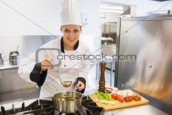 Woman tasting soup while cooking