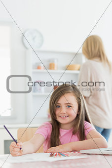Girl sitting at the kitchen smiling