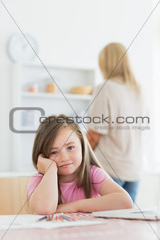 Little girl leaning on kitchen table