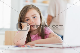 Child sitting at the table looking bored