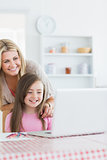 Laughing mother and girl looking at laptop