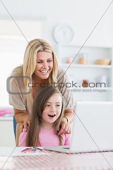 Woman and daughter sitting at the table at the kitchen