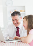 Daughter and father using laptop together
