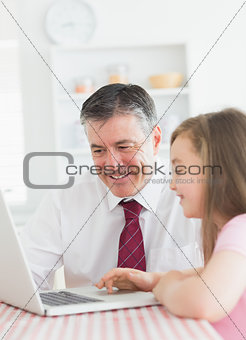 Daughter and father using laptop together