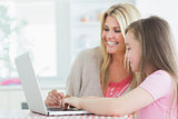 Woman and daughter sitting at the laptop