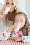 Mother and little girl drinking milk