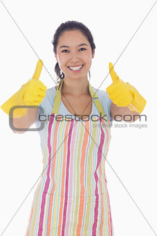Happy woman giving thumbs up in rubber gloves