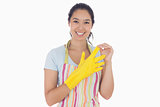 Smiling woman taking off rubber gloves