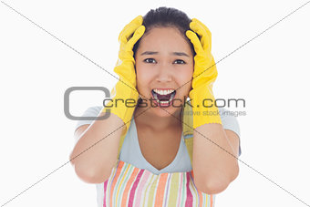 Distressed woman wearing apron and rubber gloves