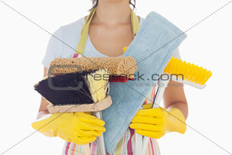 Woman holding brushes and mops