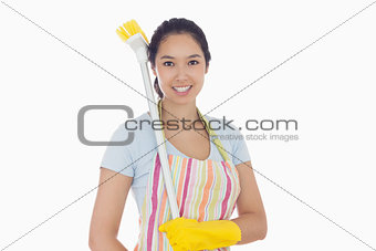 Happy woman with a broom on her shoulder