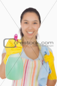 Smiling woman holding spray bottle and cloth
