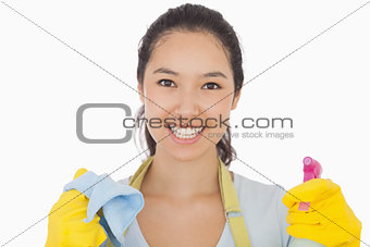 Smiling woman with cloth and spray bottle