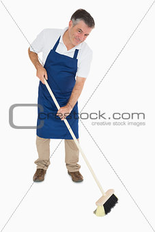 Happy man sweeping floor