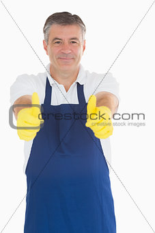 Man wearing apron giving thumbs up
