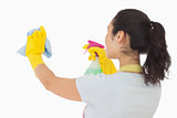 Woman spraying and wiping in rubber gloves