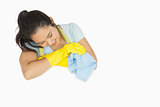Smiling woman in rubber gloves looking at white surface