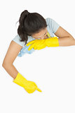 Woman in rubber gloves pointing on white surface