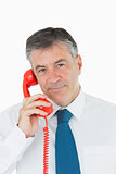 Businessman using red phone