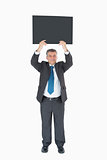 Businessman holding up blackboard