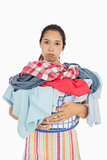 Tired woman holding full laundry basket