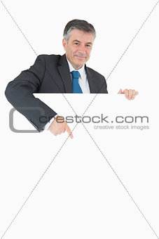 Happy businessman pointing at the board