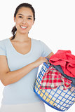 Smiling woman holding a basket full of laundry
