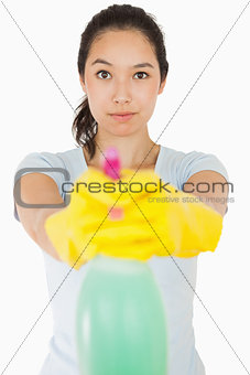 Brunette woman pointing spray bottle