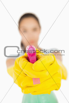 Confident woman pointing a spray bottle at the camera