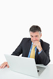 Smiling man sitting at his desk with laptop