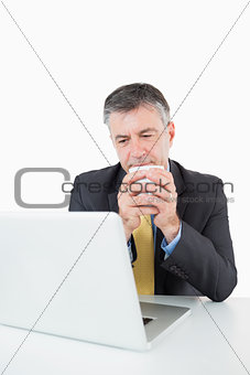 Man drinking coffee at his desk