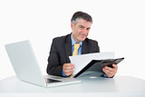 Smiling man reading documents on his desk