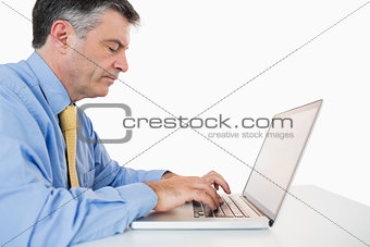 Concentrated man writing on laptop