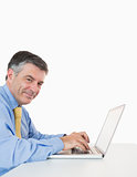 Happy man typing on a laptop