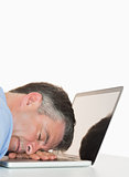 Exhausted man sleeping on his laptop