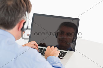 Businessman working on laptop with headset