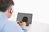 Businessman with headset working on laptop