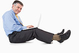 Happy man working with laptop on the floor
