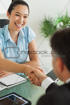 Smiling businesswoman shaking man's hand