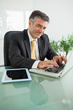 Smiling business man working on laptop
