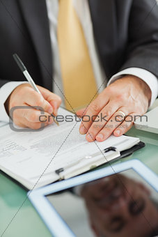 Man writing on a notepad in his office