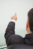 Businessman pointing to a white wall