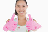 Smiling woman with gloves giving thumbs up